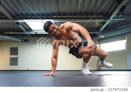Latino man smiling during his body weight workout 117471598