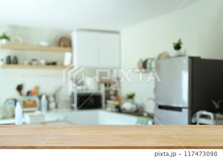 Empty wood table with blurred kitchen room in background, space text or showcasing products 117473098