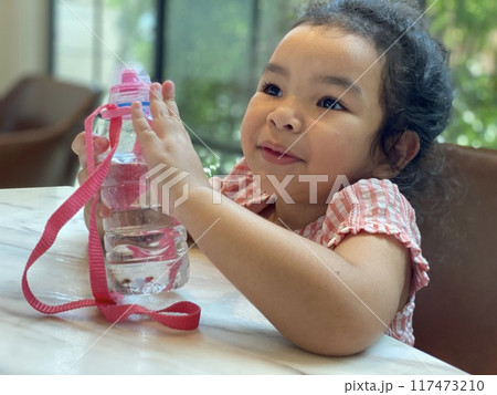 asian child girl playing water on the table 117473210