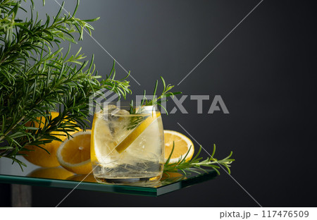 Refreshing drink with ice, lemon slices, and rosemary. 117476509