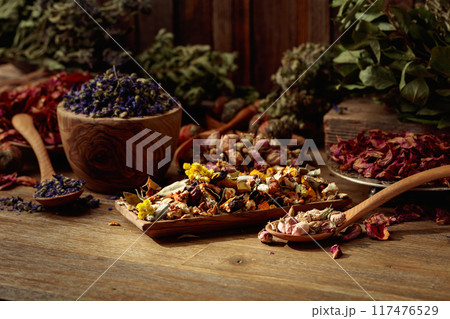 Various dried medicinal plants, herbs, and flowers on an old wooden background. 117476529