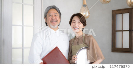 レストランなどを経営する笑顔のシニア夫婦 117476879