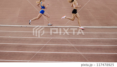 two woman athlete running 800 metres race in stadium two woman athlete running 800 metres race in stadium 117478925