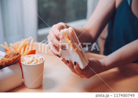 Asian healthy woman have breakfast with sandwich in morning Asian healthy woman have breakfast with sandwich in morning 117480749