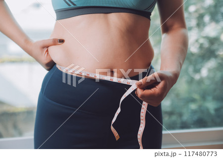 fat woman, fat belly, chubby, obese woman hand holding excessive belly fat with measure tape, woman diet lifestyle concept fat woman, fat belly, chubby, obese woman hand holding excessive belly fat with measure tape, woman diet lifestyle concept 117480773