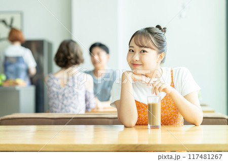 カフェでアイスカフェラテを飲む若い女性 117481267