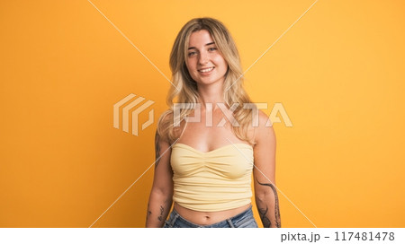 Chilling young woman standing against yellow background Chilling young woman standing against yellow background 117481478