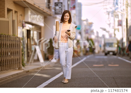 ハーフコートを着て買い物に行くミドルの女性 117481574
