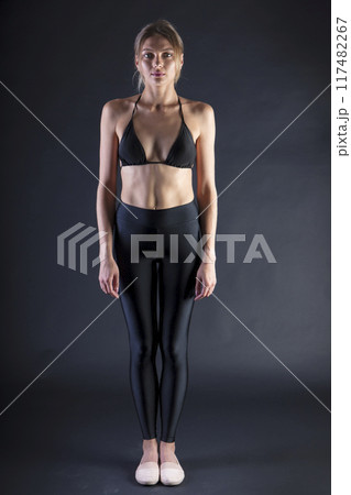 young beautiful woman on a dark background, full length studio shot 117482267