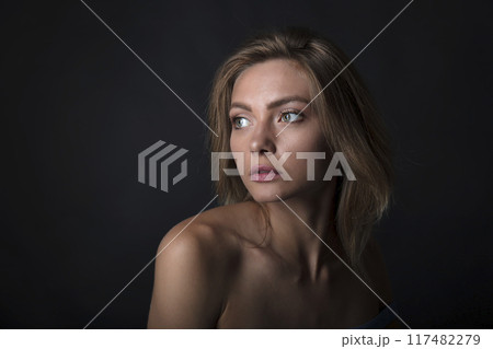 portrait of a young attractive woman on a dark background 117482279