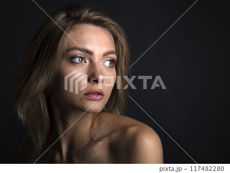 portrait of a young attractive woman on a dark background 117482280