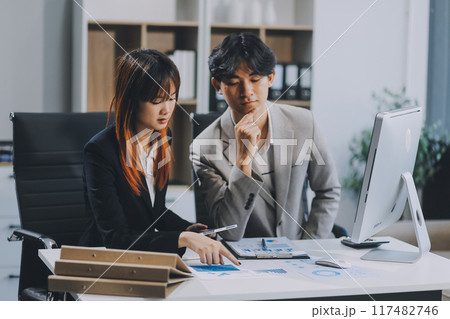 Entrepreneur Asian businessman and businesswoman discussing new business project in tablet in modern Meeting In Modern Office, Asian business casual concept. 117482746