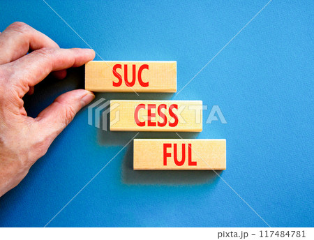Successful symbol. Concept word Successful on beautiful wooden blocks. Businessman hand. Beautiful blue background. Business successful concept. Copy space. Successful symbol. Concept word Successful on beautiful wooden blocks. Businessman hand. Beautiful blue background. Business successful concept. Copy space. 117484781