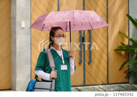Nurse Wearing Facemask Holding an Open Umbrella Nurse Wearing Facemask Holding an Open Umbrella 117485342
