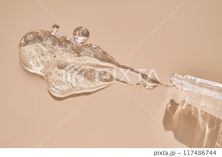 Pipette with cosmetic hyaluronic anti-aging serum on a dusty pink background. 117486744
