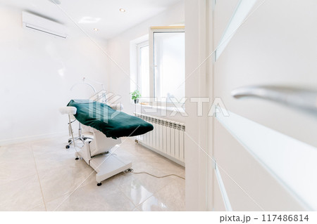Stylish room interior with massage table in BEAUTY salon. A medical office with a green table and white walls. Stylish room interior with massage table in BEAUTY salon. A medical office with a green table and white walls. 117486814