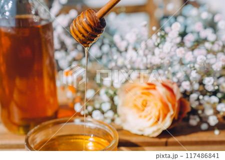 ハニーディッパーから滴り落ちる黄金のはちみつ 117486841