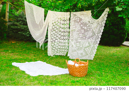 Washing day with laundry on clothesline, White clean sheets outdoors. 117487090