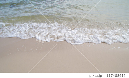 Beautiful white sandy beach seashore with crashing waves. Beautiful white sandy beach seashore with crashing waves. 117488413