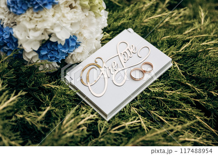 Elegant wedding details with floral bouquet and 'One Love' sign, symbolizing eternal unity 117488954