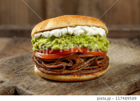 CHILEAN FOOD. Sandwich Churrasco italiano on colors of italian flag. Popular sandwich with round bread, beef, avocado guacamole, tomatoes and mayonnaise 117489589