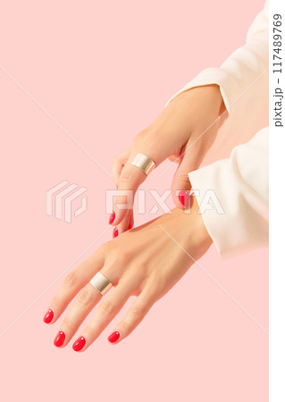 Womans hands with red manicure on pink background. Beauty salon concept Womans hands with red manicure on pink background. Beauty salon concept 117489769