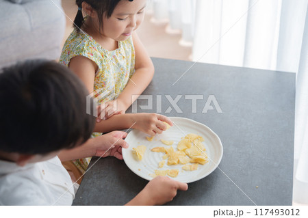 お菓子のポテトチップスを食べる子供 お菓子のポテトチップスを食べる子供 117493012