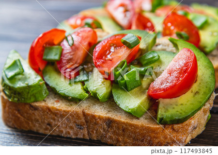 Avocado toast topped with tomato and green onion on a slice of carrot bread Avocado toast topped with tomato and green onion on a slice of carrot bread 117493845