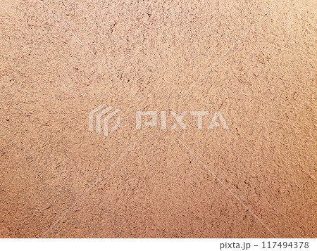 明るく薄い赤茶色の土壁のなかに藁の風合いが残る表面の横長の背景画像 117494378