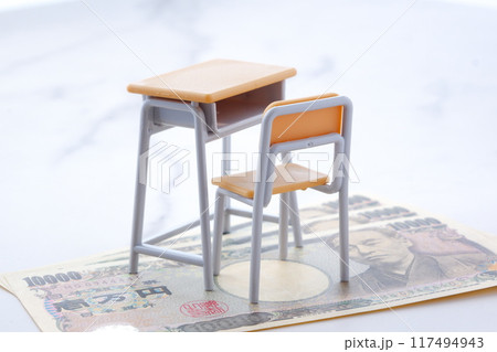 学校の机と椅子、お金がイメージする、高騰する教育費のイメージ 学校の机と椅子、お金がイメージする、高騰する教育費のイメージ 117494943