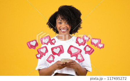 Smiling millennial african american curly woman in white t-shirt typing on smartphone, isolated on yellow studio background. Dating app, communication at gadget Smiling millennial african american curly woman in white t-shirt typing on smartphone, isolated on yellow studio background. Dating app, communication at gadget 117495272