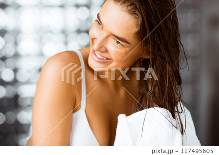 Millennial woman drying hair with towel after taking shower, closeup Millennial woman drying hair with towel after taking shower, closeup 117495605