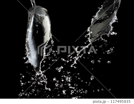 Pouring Water on pants object to create shape form splash fluttering in droplet and wave. Pouring water to object make curve drop splash in directions. Black background isolated 117495835