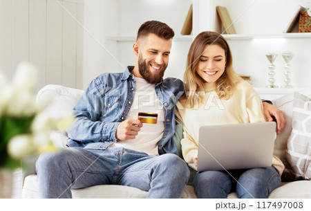 E-shopping. Happy Couple Using Credit Card, Surfing Internet On Laptop 117497008