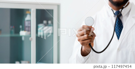 Male doctor listening with stethoscope over light background, copy space, crop Male doctor listening with stethoscope over light background, copy space, crop 117497454