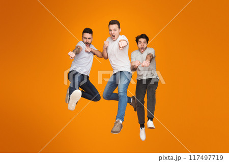 Three european guys showcase energetic friendship with a mid-air jump, expressing joy and carefree mates Three european guys showcase energetic friendship with a mid-air jump, expressing joy and carefree mates 117497719