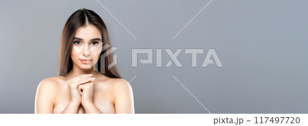 A woman with no clothes, her hands crossed over her chest, standing in a simple pose. The focus is on her body and the gesture of covering herself, panorama with copy space A woman with no clothes, her hands crossed over her chest, standing in a simple pose. The focus is on her body and the gesture of covering herself, panorama with copy space 117497720