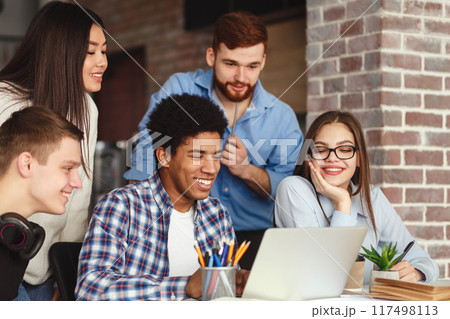 Friends preparing for final exams togehter, sitting in library and using laptop 117498113