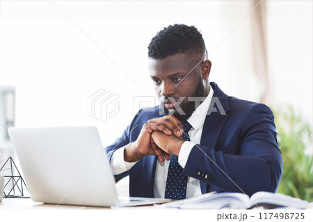 Concentrated young african american guy working with laptop in office, copy space Concentrated young african american guy working with laptop in office, copy space 117498725
