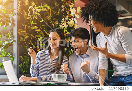 Multiethnic colleagues celebrate win success, feeling happy looking at laptop during business lunch, empty space 117498859