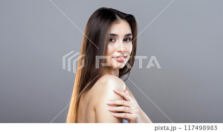 A woman with flowing long hair strikes a pose for a photograph, looking directly at the camera with a confident expression. She stands in a relaxed stance, showcasing her beautiful hair A woman with flowing long hair strikes a pose for a photograph, looking directly at the camera with a confident expression. She stands in a relaxed stance, showcasing her beautiful hair 117498983