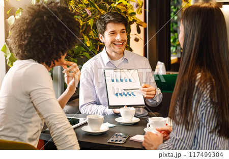 Managers analyzing chart at a business lunch, discussing successful project at cafe, free space Managers analyzing chart at a business lunch, discussing successful project at cafe, free space 117499304