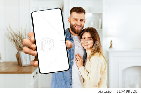 Buying Apartment Concept. Couple Showing Key And Hugging, Free Space Buying Apartment Concept. Couple Showing Key And Hugging, Free Space 117499329