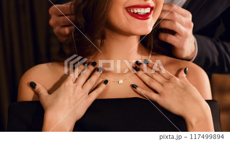 Handsome man wearing necklace on his attractive young woman while have date. Happy Saint Valentine's Day concept Handsome man wearing necklace on his attractive young woman while have date. Happy Saint Valentine's Day concept 117499894