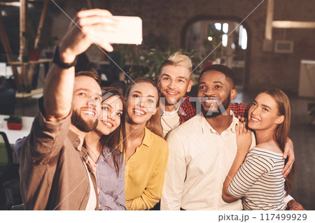 Happy international creative business team taking selfie at office 117499929