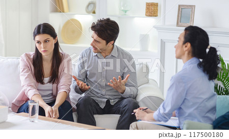 An emotional therapy session captures a young couple discussing their feelings with a woman psychologist, aimed at healing and mutual understanding. An emotional therapy session captures a young couple discussing their feelings with a woman psychologist, aimed at healing and mutual understanding. 117500180