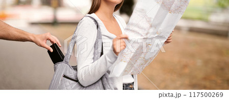 Travel And Pickpocketing. Thief Stealing Wallet From Tourist Girl's Bag While She Looking At Map Standing Outdoor. Cropped, Selective Focus 117500269