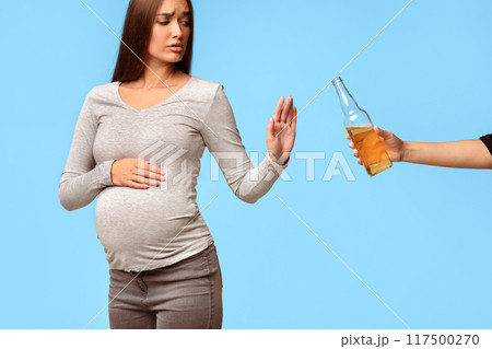 Pregnancy And Alcohol. Pregnant Lady Gesturing No Refusing To Take Beer Bottle Standing Over Gray Background. Studio Shot 117500270