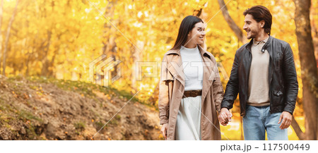 Young happy man and woman having romantic date at golden forest, enjoying time together Young happy man and woman having romantic date at golden forest, enjoying time together 117500449