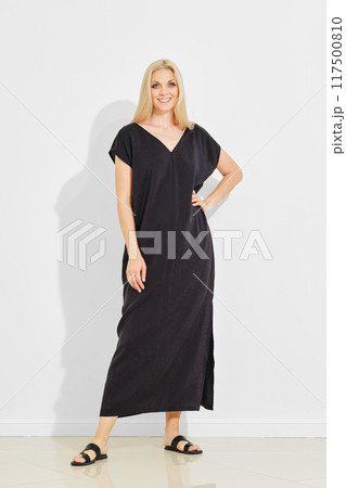 woman in black v neck sundress and leather sandals posing 117500810